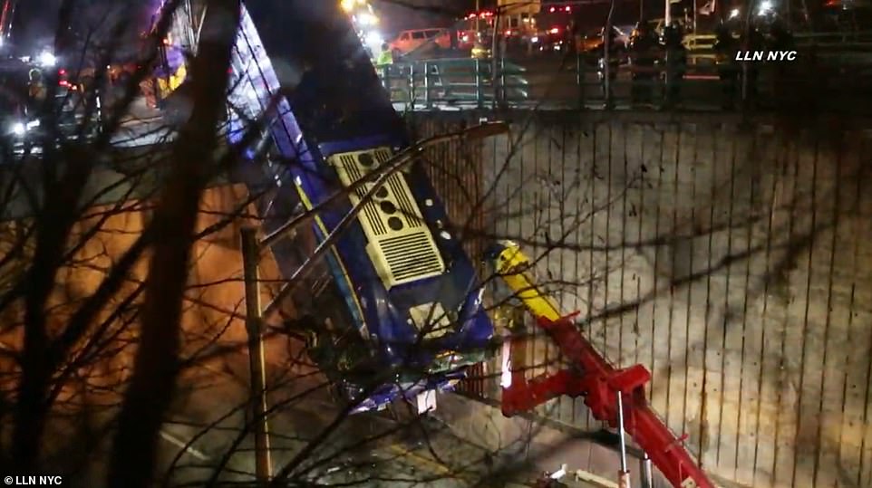 A lift is used to get the bus back off from dangling from the road