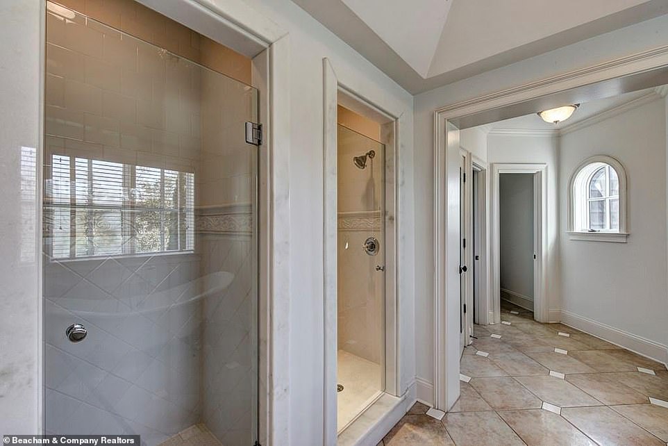 Making it work: One bathroom that has been done all in white features two separate showers directly next to one another, so that if a couple is staying there no one has to argue over who gets to bathe first