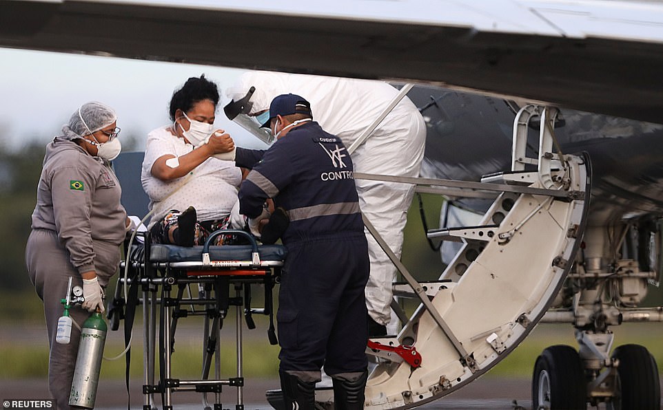 A health worker helps a COVID-19 patient board a Brazilian Air Force airplane, before being moved to Maranhao state