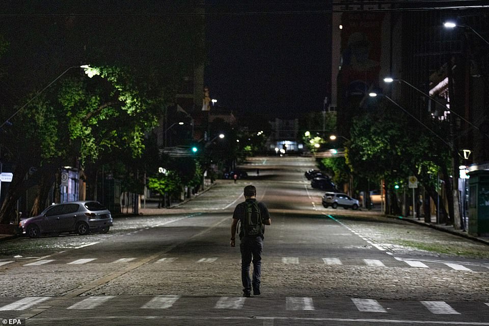 A man walks on an empty street in Manaus after the governor of Amazonas imposed the curfew to curb the infection rate