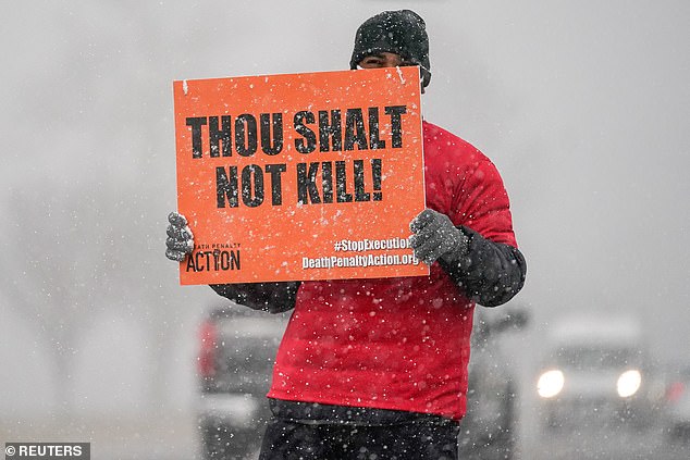 An activist in opposition to the death penalty protests during a snowstorm outside of the United States Penitentiary in Terre Haute, Indiana on Thursday