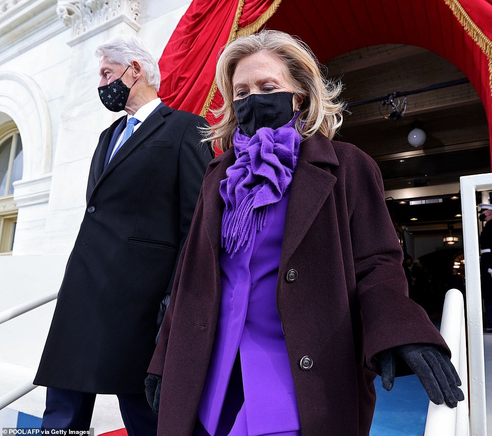 Keeping warm: Mrs. Clinton was bundled up in a scarf that matched her suit and black suede gloves