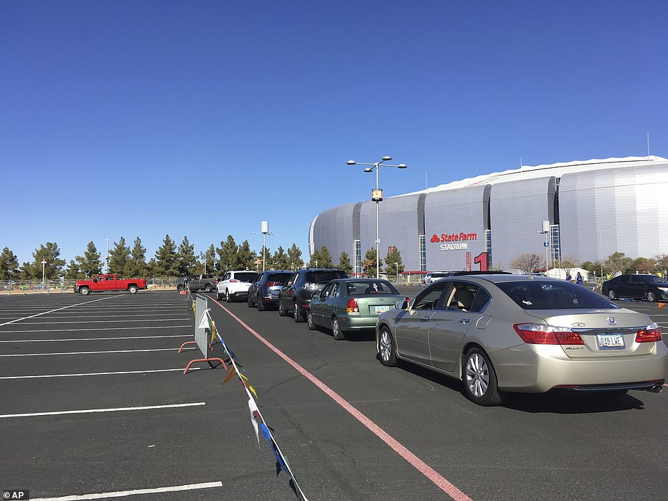 In line: Drivers wait to get the COVID vaccine in the parking lot of the State Farm Stadium in Glendale, Arizona