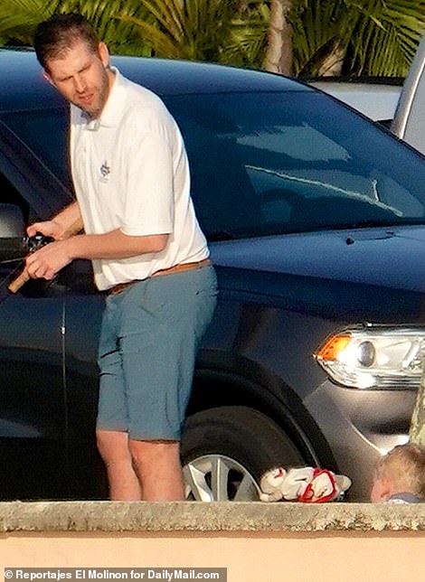 Eric looks to be the doting dad while trying to reel in fish at his father's Mar-a-Lago estate on Thursday