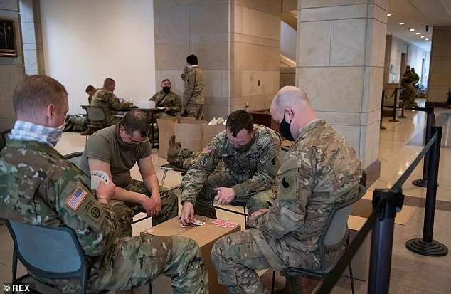 Members of the National Guard play cards in the Capitol Visitors Center at the US Capitol, the day after the inauguration of President Joe Biden in Washington, DC