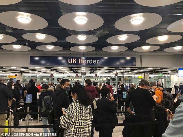 People queue at terminal 5 of Heathrow Airport on Friday, as the spread of the coronavirus disease continues
