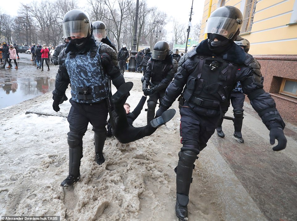 Riot police officers in St Petersburg detain a participant in an unauthorised rally in support of Russian opposition activist Alexei Navalny