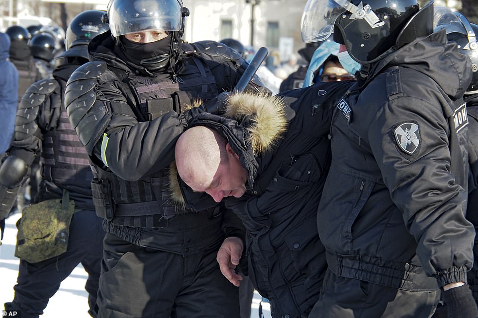 Pictured: Police detain a man during a protest against the jailing of opposition leader Alexei Navalny in Khabarovsk, 3,800 miles east of Moscow on Saturday, January 23. The protests are against Vladimir Putin and the jailing of opposition leader Alexei Navalny last Sunday