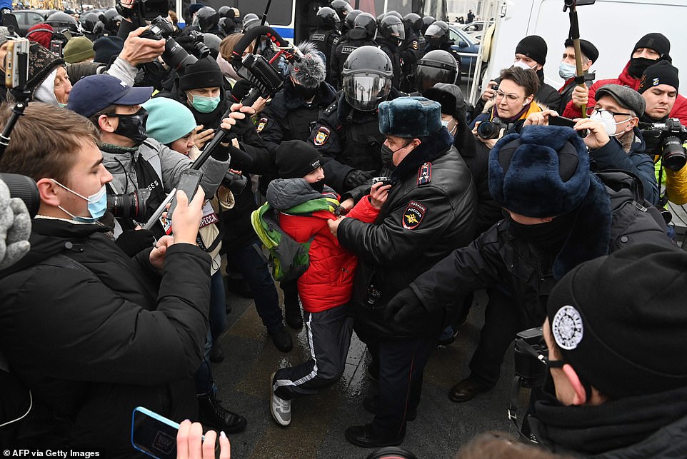 Police detain a boy during a rally in support of jailed opposition leader Alexei Navalny in downtown Moscow on January 23