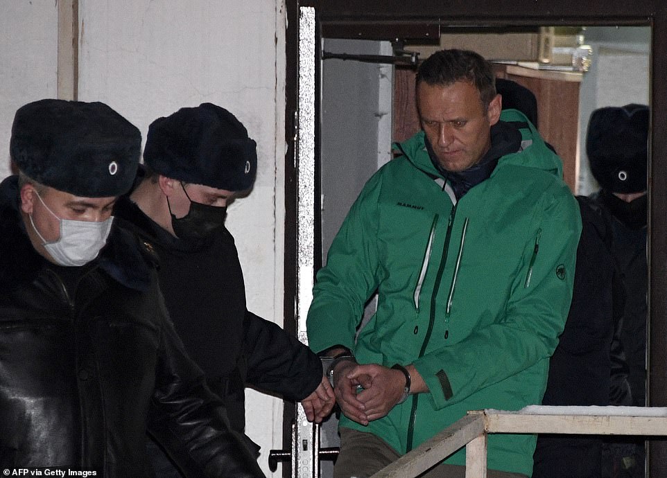 Opposition leader Alexei Navalny is escorted out of a police station on January 18 in Khimki, outside Moscow, following the court ruling that ordered him jailed for 30 days. Following his arrest, he called for his supporters to take to the streets in protest