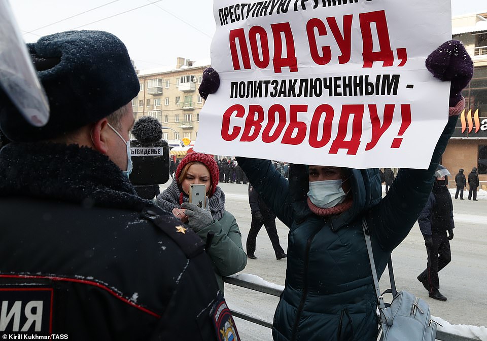 A participant holds a poster reading 'freedom to political prisoners' during an unauthorised rally in support of Russian opposition activist Alexei Navalny near Lenina Square, January 23