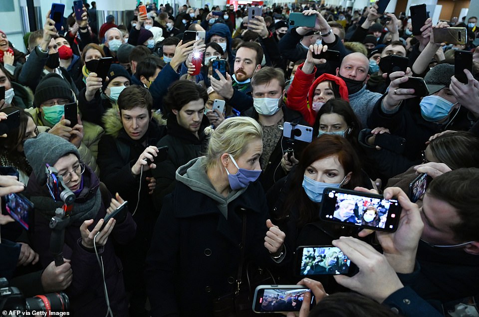 Navalny's wife Yulia Navalnaya is seen surrounded by people as she leaves Moscow's Sheremetyevo airport following the arrest