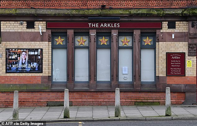 Blinds cover the windows of a pub, temporarily closed due to the COVID-19 pandemic, near Anfield stadium, in Liverpool, on January 17, 2021