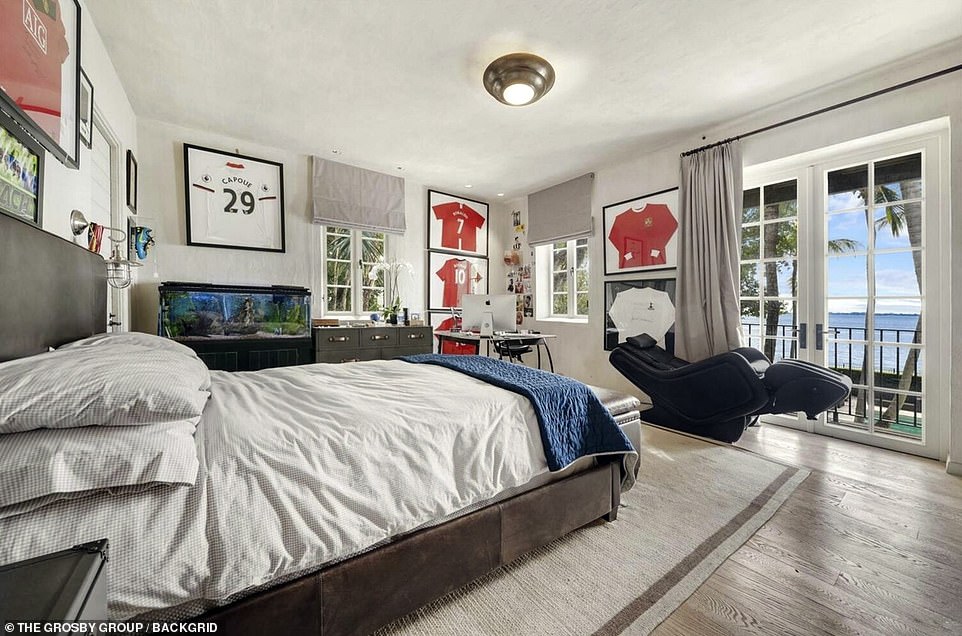 One of the six bedrooms in the property features football memorabilia and french doors looking out to the Miami coast