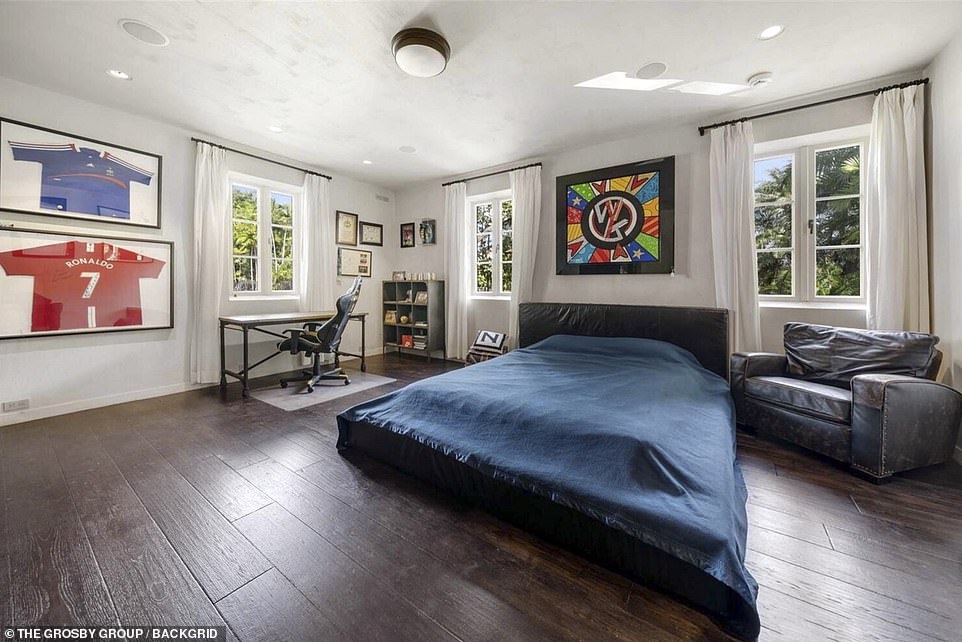 Another double bedroom with wooden floors and football memorabilia is pictured in the $40million mansion