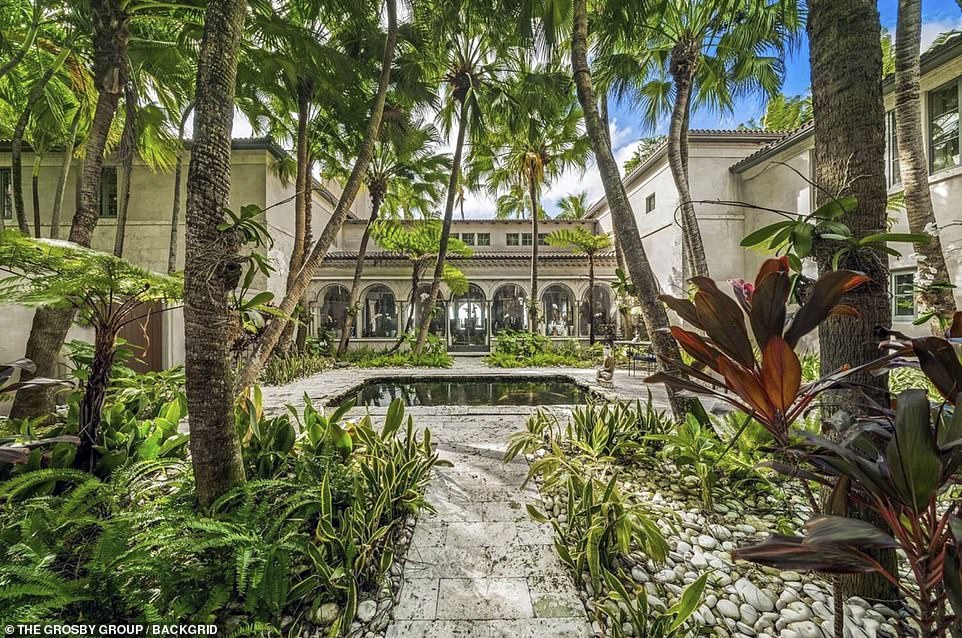 The relationship between Collins and Orianne continued to clash after she made a series of personal attacks at her ex in court documents. Pictured: An ornate wrought-iron gate opens to
a forest of curved coconut palm trees and a 6,000-gallon koi pond