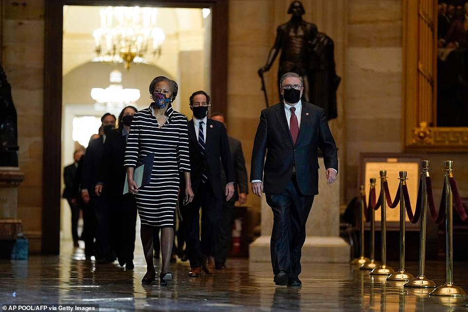 Crime scene: Clerk of the House Cheryl Johnson along with House Sergeant-at-Arms Tim Blodgett lead the Democratic House impeachment managers as they walk through Statuary Hall. It is less than three weeks since MAGA rioters stormed into the Capitol