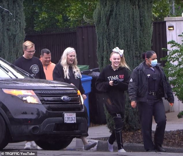 The grinning 17-year-old influencer (2-R) forgot to put on shoes, but remembered her camera as she and three others were ordered to come outside with their hands up in the rain