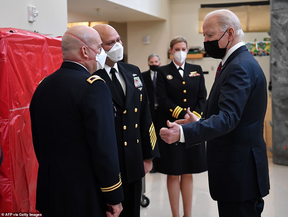 President Joe Biden speaks with the Director of Walter Reed National Military Medical Center, Col. Andrew Barr (left), and Command Master Chief Randy Swanson (second left)