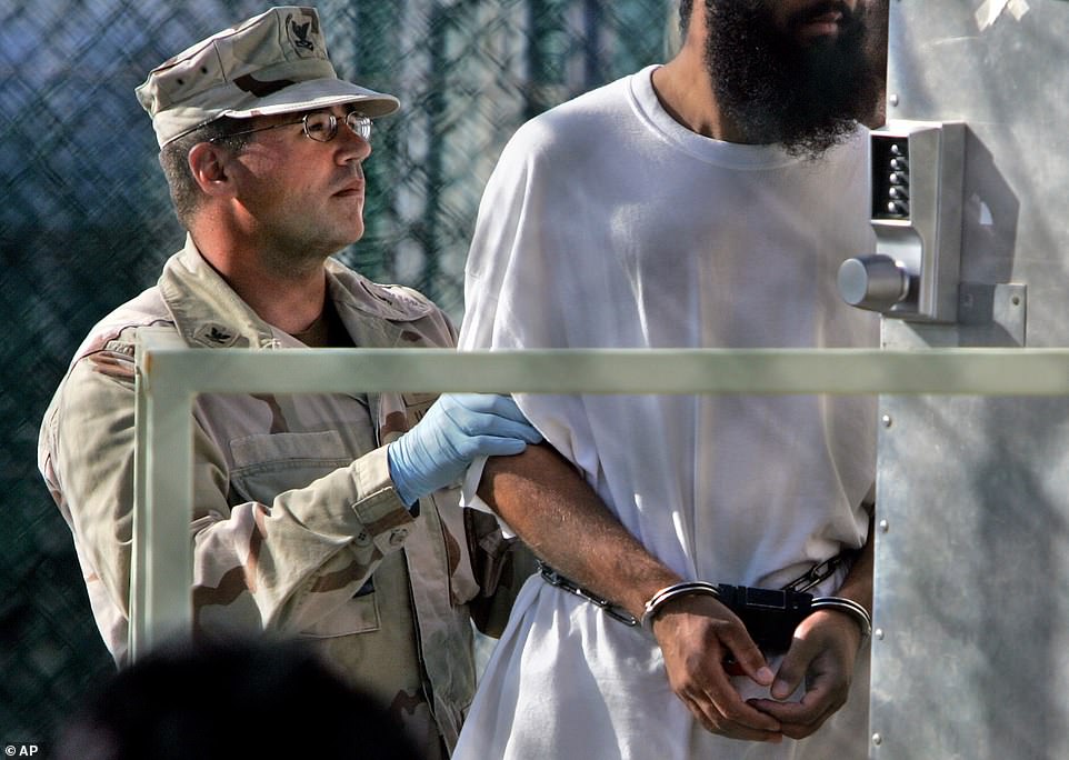 A guard escorts a shackled detainee into a trailer, at Guantanamo Bay U.S. Naval Base, Cuba, in this April 5, 2006 file photo