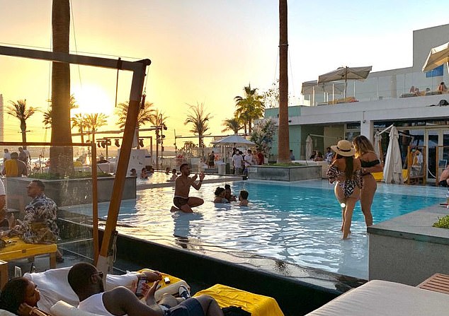 Instagram influencers pose in a swimming pool in Dubai yesterday as other Britons rushed to get home before the 1pm deadline