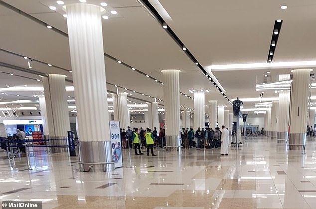 Air passengers are pictured inside Dubai Airport in the United Arab Emirates this morning which was mostly quiet