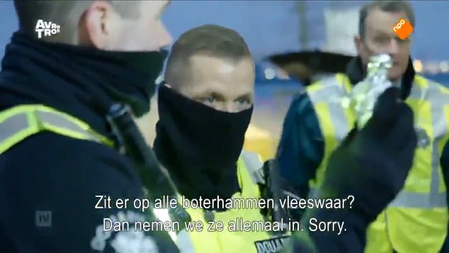 Pictured: A still from footage showing Dutch police officers confiscating food from a British lorry driver. Holding up the man's ham sandwiches wrapped in foul, they are seen telling him that the sandwiches will have to be confiscated because they have ham in them