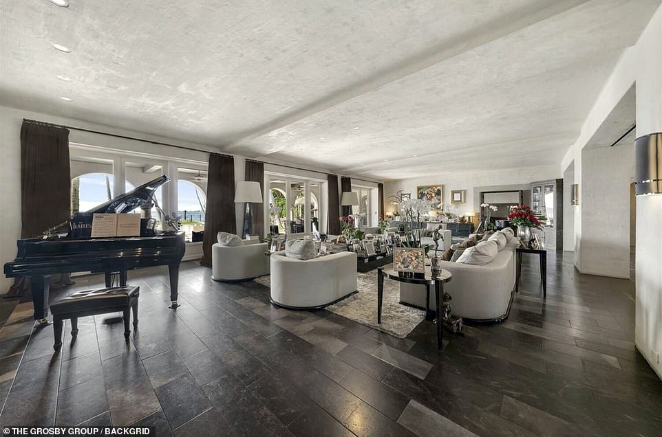 The interior of Phil Collins' luxury Miami Beach mansion has been pictured as the singer takes back possession of the property from his ex-wife. Pictured: A lounge area with a black grand piano at the mansion