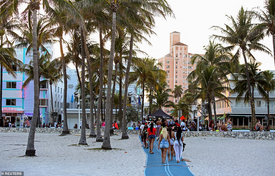 People attend a party on a walkway near the beach, during spring break in Miami Beach on March 25 ahead of the curfew that was enforced by authorities