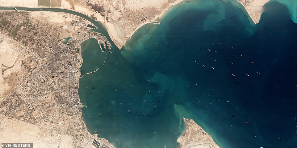 A satellite image taken above the Gulf of Suez where it leads into the Suez Canal (top left) shows at least 50 large ships at anchor as they wait for a stricken container ship to be freed from where it has lodged in the narrow waterway