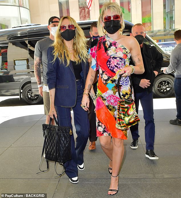 Mommy by her side: Mom Tish held on to a black quilted bag as she walked with Miley
