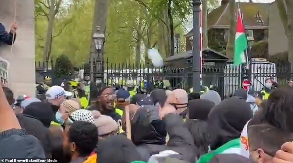 Pictured: The moment a drink is thrown at police officers outside the gates to Kensington Palace by pro-Palestine protesters