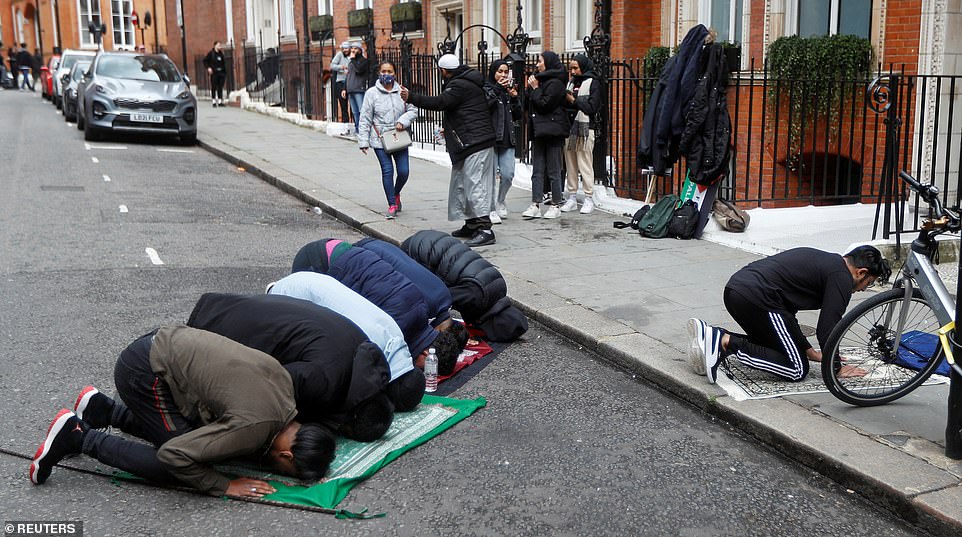Muslims who attended the pro-Palestinian protest take a moment to pray in a street in Kensington