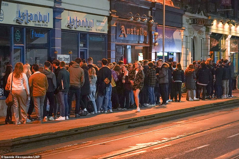 Sheffield: Students wait outside a bar in West Street as it prepares to serve customers after midnight to mark the latest lifting of lockdown measures