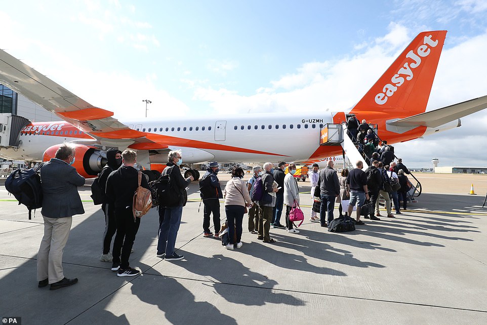 Passengers prepare to board an easyJet flight to Faro at Gatwick Airport this morning