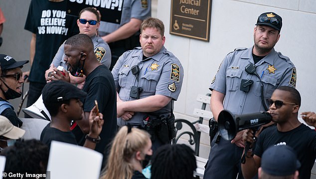 A police reform plan that would encourage officers to intervene when they notice another member of their union acting wrongfully. In this picture, police officers in Charleston, South Carolina watched as protestors called for justice for Jamal Sutherland who was shocked with a stun gun