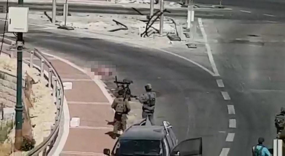 Israel soldiers after the shooting standing in the road close to the woman's lifeless body