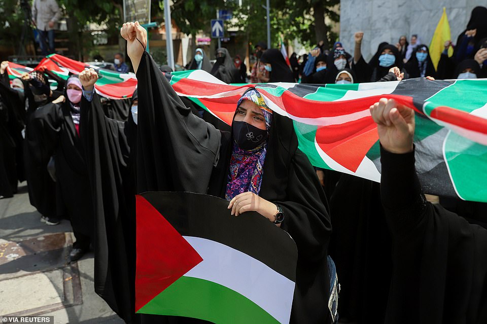 An Iranian woman holds the Palestinian flag during a protest to express solidarity with the Palestinian people amid a flare-up of Israeli-Palestinian violence, in Tehran, Iran May 18