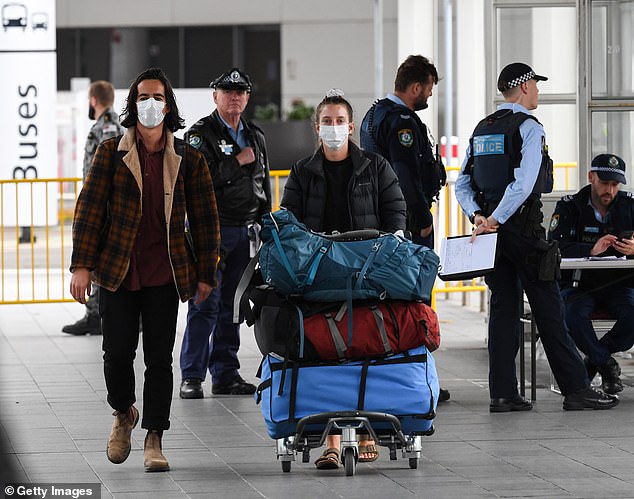 Prime Minister Scott Morrison has refused to reveal the benchmark for reopening the international border. Pictured: Travellers arriving at Sydney Airport